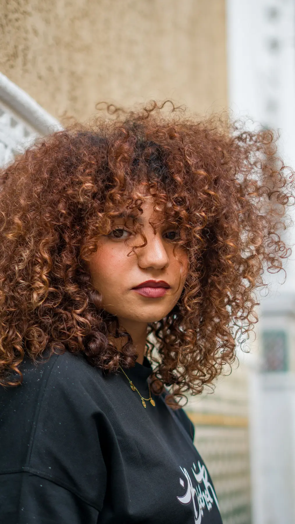cette femme se demande si elle a les cheveux bouclés ou frisés