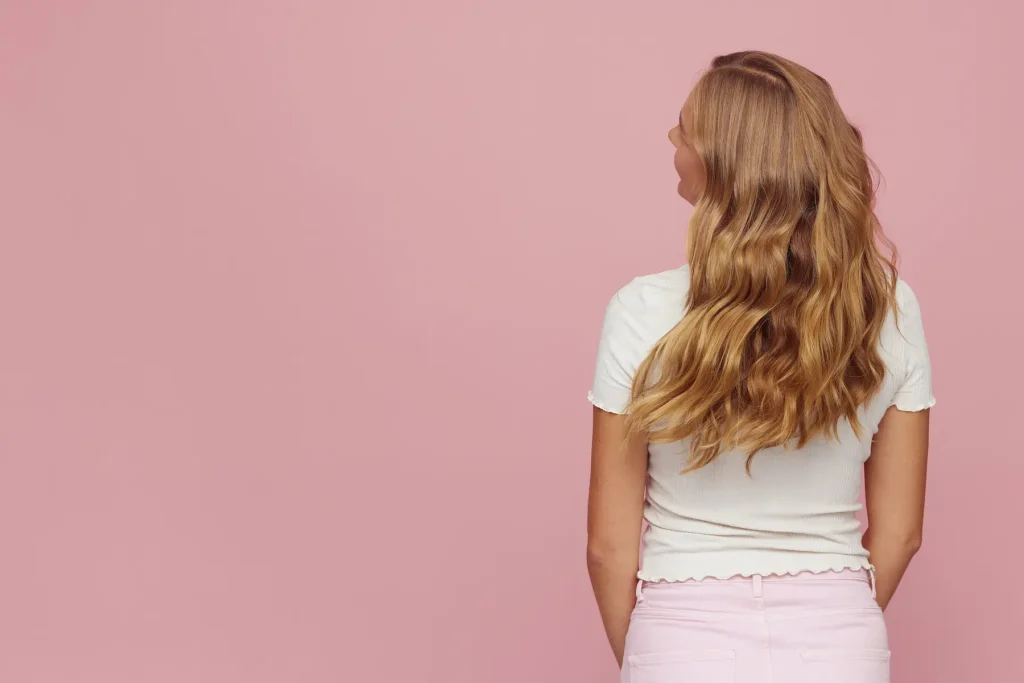 femme qui secoue ses cheveux ondulés naturellement