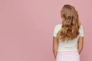 femme qui secoue ses cheveux ondulés naturellement